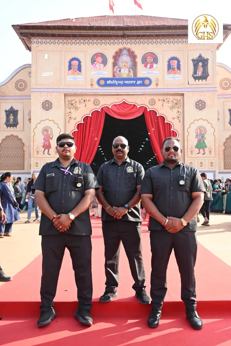 Three Golden Hawk Security guards on a red carpet in front of a decorated entrance arch